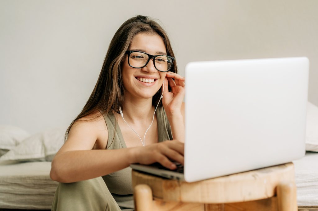 freelancer woman at online meeting using laptop and headphones