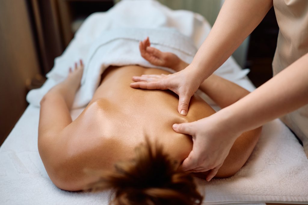 unrecognizable woman having back massage at health spa